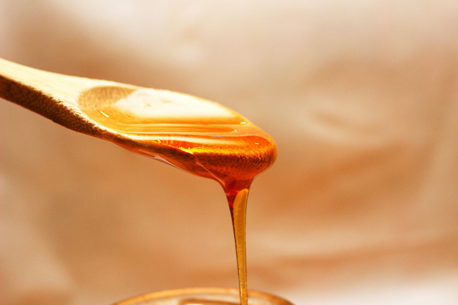 honey dripping off of a spoon